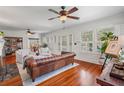 Bright living room featuring hardwood floors, white walls, and a stylish leather couch under a ceiling fan at 1311 Beach Ne Dr, St Petersburg, FL 33701