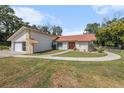 Beautiful ranch-style home with a metal roof, stone accents, and a curved walkway at 14047 Drysdale St, Spring Hill, FL 34609