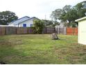 Fenced backyard with grass and mature trees providing shade at 1554 Tilley Ave, Clearwater, FL 33756