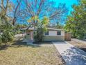 Charming single-story home with a pink door, a well-maintained lawn, and a freshly paved driveway at 1800 27Th N Ave, St Petersburg, FL 33713