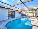 Gorgeous screened-in pool area with a clear blue pool and a comfortable patio for relaxing and entertaining at 2441 Blossom Lake Dr, Holiday, FL 34691