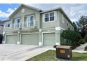 Townhouse exterior with a three-car garage, balconies, and well-maintained landscaping at 27901 Pleasure Ride Loop, Wesley Chapel, FL 33544