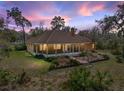 Rear exterior view of house with screen porch at twilight with colorful sky at 3512 Kalebs Forest Trl, Dover, FL 33527