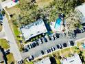 Overhead shot of condo buildings showcasing a pool, parking lot, and surrounding greenery at 700 Lyndhurst St # 1024, Dunedin, FL 34698