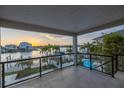 A balcony view overlooking a swimming pool, canal, and sunset creates a serene waterfront living experience at 8505 Blind Pass Dr, Treasure Island, FL 33706