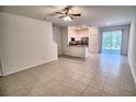 Open-concept living room with tile flooring that flows into an adjoining kitchen and dining area at 11115 Wishing Cloud Rd, Land O Lakes, FL 34638