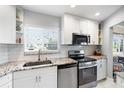 Well-lit kitchen with white cabinets, stainless steel appliances, and granite countertops at 1200 N Shore Ne Dr # 110, St Petersburg, FL 33701