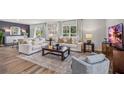 Bright living room featuring a large window, hardwood floors, plush sofas, and stylish decor at 12020 Lansing Gln, Parrish, FL 34219