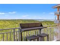 Balcony overlooking a scenic forest and ocean view, furnished with a cozy bar-height table and seating at 12033 Gandy N Blvd # 175, St Petersburg, FL 33702