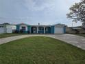 Charming blue home with a well-manicured lawn, brick driveway, and a one car garage at 12734 2Nd Isle, Hudson, FL 34667