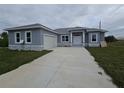 Attractive gray stucco home with a well-manicured lawn and a concrete driveway at 14300 Kay Ln, Port Charlotte, FL 33981