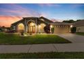 Charming home with beautiful landscaping, arched windows, and a two-car garage at 2015 Golf Manor Blvd, Valrico, FL 33596