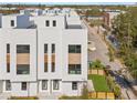 Aerial view of a modern townhouse with a white exterior, multiple windows, and a well-manicured lawn at 307 15Th N St, St Petersburg, FL 33705