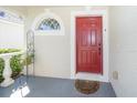 Inviting front entrance featuring a red door, decorative window, and well-maintained porch area, creating a warm welcome at 31826 Larkenheath Dr, Wesley Chapel, FL 33543