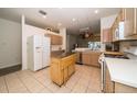 Functional kitchen featuring wood cabinets, tile flooring, a movable kitchen island and modern appliances at 31826 Larkenheath Dr, Wesley Chapel, FL 33543