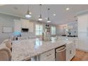 Kitchen island with granite countertop, stainless steel appliances, and ample seating at 405 Tennessee Ave, Crystal Beach, FL 34681