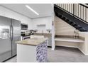 Modern kitchen featuring white cabinetry, stainless steel appliances, and a stylish center island at 4221 W Spruce St # 1407, Tampa, FL 33607