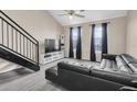 Bright living room boasts a modern black leather sofa, staircase, and natural light from large windows at 4221 W Spruce St # 1407, Tampa, FL 33607