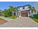 Two-story home with a brick driveway and a well-maintained lawn at 47 Adalia Ave, Tampa, FL 33606