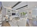 Open-concept living room features built-in shelving, beamed ceilings and French doors leading to the outside at 47 Adalia Ave, Tampa, FL 33606