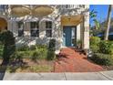 Charming home featuring a brick walkway leading to a blue front door, accented by awnings and lush landscaping at 6030 Printery St # 108, Tampa, FL 33616