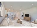 Bright open-concept living room with hardwood floors, neutral tones, modern lighting, and plenty of space at 6042 Golden Nettle Dr, Apollo Beach, FL 33572