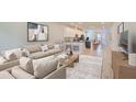 Bright, open-concept living room and kitchen with hardwood floors, a large sofa, and modern decor at 6042 Golden Nettle Dr, Apollo Beach, FL 33572