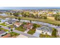 Aerial view of a suburban home with a large backyard, canal, and waterfront community in the distance at 811 Eagle Ln, Apollo Beach, FL 33572