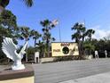 Community entrance with large signage, American and Florida flags, and beautiful landscaping and an eagle statue at 8158 Eagles Park N Dr, St Petersburg, FL 33709