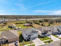 Aerial view of a gray two-story home with a large driveway in a suburban neighborhood near a highway at 8816 Mugnai St, Riverview, FL 33578