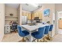 Open kitchen with white quartz countertops, blue velvet seating, and stainless steel appliances, plus a built-in workspace at 10115 Courtney Palms Blvd # 202, Tampa, FL 33619