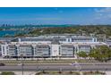 Wide view of condo building highlighting the exterior architecture, design, and landscaping along a busy street at 131 Bluff View Dr # 208, Belleair Bluffs, FL 33770