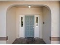 Inviting entryway features a stylish gray front door with sidelights and decorative brick pavers at 13112 Groveland St, Spring Hill, FL 34609