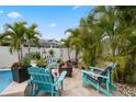 Inviting poolside patio featuring a fire pit, comfortable seating, and tropical palm trees at 1350 Maple Sw St, Largo, FL 33770