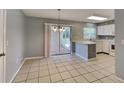 Well-lit open floorplan with white cabinetry, stainless steel appliances, and sliding door to the exterior at 18236 Ackerman Ave, Port Charlotte, FL 33948