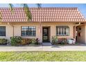 Inviting front entrance with a glass storm door, lovely landscaping, and an American flag hanging outside at 19029 Us Highway 19 N # 30H, Clearwater, FL 33764