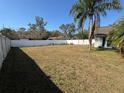 Spacious backyard with well-maintained lawn, enclosed by a tall white privacy fence at 2218 Egret Walk Ct, New Port Richey, FL 34655