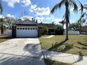 Attractive home featuring a two-car garage, stone accents, and a concrete driveway leading to the entrance at 2218 Egret Walk Ct, New Port Richey, FL 34655