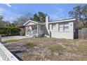 A single story house with a white porch featuring a brick chimney, and an unkempt lawn at 2308 Chipco St, Tampa, FL 33605