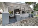 Charming home showcasing a covered porch with a swing and classic white trim and gray accents at 2921 W El Prado Blvd, Tampa, FL 33629