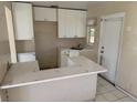 View of kitchen, featuring white cabinets, tile floor, and laminate countertops at 4501 27Th S Ave, Gulfport, FL 33711