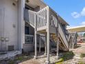 Exterior wooden staircase providing access to upper-level units with railings and landing at 4928 W Gandy Blvd # G203, Tampa, FL 33611
