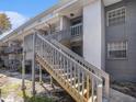 Exterior wooden staircase providing access to upper-level units with railings and landing at 4928 W Gandy Blvd # G203, Tampa, FL 33611