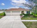 Charming single-story home with a three-car garage, a well-maintained lawn, and landscaping at 5325 Sandy Shell Dr, Apollo Beach, FL 33572