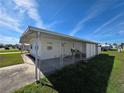 Single-story home featuring a covered parking area and well-maintained lawn at 5403 Comanche St, Zephyrhills, FL 33542