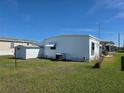 Features the home's exterior, including a shed and well-maintained lawn at 5403 Comanche St, Zephyrhills, FL 33542