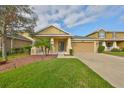 Well-maintained home with a manicured lawn, appealing landscaping, and a two-car garage at 9244 Bella Vita Cir, Land O Lakes, FL 34637