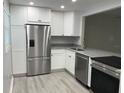 Modern kitchen featuring stainless steel appliances, white cabinets, and granite countertops at 10351 Regal Dr # 10, Largo, FL 33774