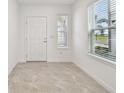 Bright foyer featuring neutral tile floors, white walls, and a large window providing natural light at 10352 Cross River Trl, Parrish, FL 34219