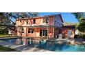 A lovely backyard with a sparkling swimming pool and an outdoor patio area perfect for entertaining at 1550 Chateau Wood Dr, Clearwater, FL 33764